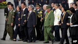 Para penerima medali kehormatan membawa karangan bunga dalam upacara Hari Pahlawan di Lapangan Tiananmen, Senin, 30 September 2019, menjelang perayaan hari jadi Republik Rakyat China ke-70. (Foto: AP)