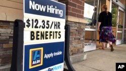 FILE- A "Now Hiring" sign is outside Aldi supermarket in Salem, New Hampshire, July 17, 2018. The Labor Department reports, Oct. 16, 2018, on job openings and labor turnover for August.