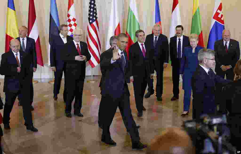 U.S. President Barack Obama and Polish President Bronislaw Komorowski walk away after a group photo with Central and Eastern European Leaders in Warsaw, June 3, 2014.