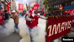 Para demonstran Turki di Lapangan Taksim, Istanbul berlarian setelah polisi menembakkan gas air mata, Kamis (1/5).