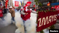 A protester reacts as police fires tear gas during a May Day demonstration in Istanbul, May 1, 2014.