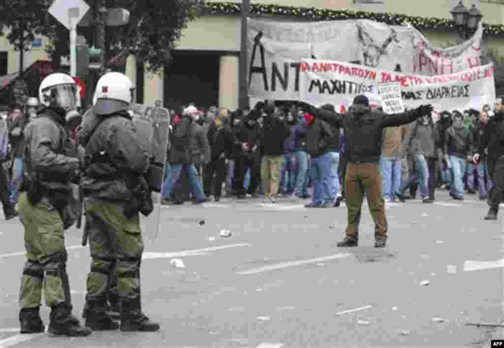 A protester taunts police during clashes in Athens,Wednesday, Dec. 15, 2010. Hundreds of protesters clashed with riot police across central Athens, smashing cars and hurling gasoline bombs during a massive labor protest against the government's austerity 