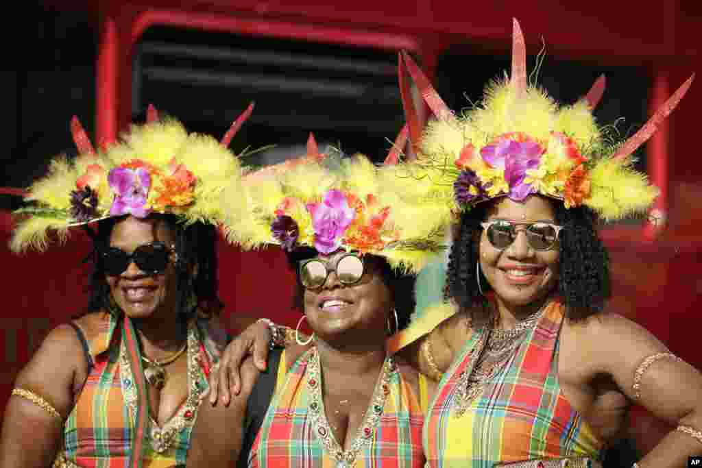 Costumed revelers pose for a photo, ahead of the parade during the Notting Hill Carnival in London.