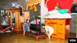 Warga Quang Binh, Vietnam, sedang memidahkan perabotan rumahnya yang dilanda banjir (18/10). Banjir telah melanda Vietnam sejak September lalu.