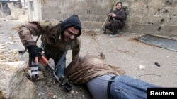A Free Syrian Army fighter drags his comrade who was shot by sniper fire [and died soon after] during heavy fighting in the Ain Tarma neighborhood of Damascus, Syria, January 30, 2013.