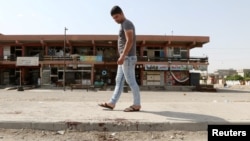 A man looks at bloodstains on a roadway after a bomb explosion in the ethnically mixed Iraqi oil city of Kirkuk, Iraq, June 9, 2018.