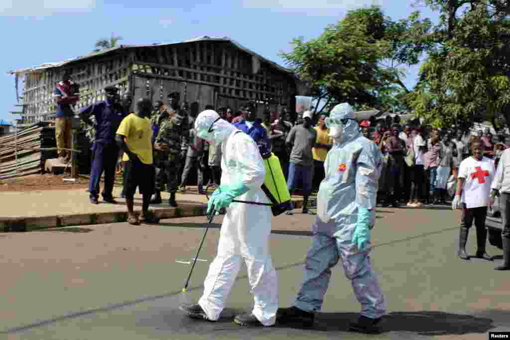 سیرالیون میں طبی کارکن ایبولا وائرس کے بچاؤ کے لیے اسپرے کر رہے ہیں۔ 