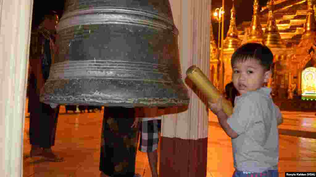 A boy rings a bell at the Shwedagon Pagoda in Yangon, Myanmar, Nov. 10, 2015.