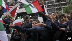 Schoolchildren wave Italian flags on a float in the Columbus Day parade in New York, Oct. 13, 2014. The parade is organized by the Columbus Citizens Foundation, and is billed as the world's largest celebration of Italian-American heritage and culture.