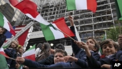 Escolares ondean bandeas italianas en una carroza en el desfile del Día de Colón durante el desfile en Nueva York en 2014.
