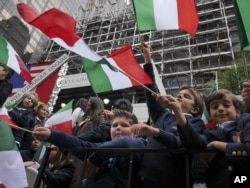 Schoolchildren wave Italian flags on a float in the Columbus Day parade in New York, Oct. 13, 2014. The parade is organized by the Columbus Citizens Foundation, and is billed as the world's largest celebration of Italian-American heritage and culture.
