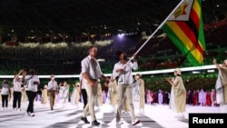 Flag bearers Peter Purcell-Gilpin of Zimbabwe and Donata Katai of Zimbabwe lead their contingent during the athletes' parade at the opening ceremony REUTERS/Kai Pfaffenbach