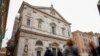 La gente camina junto a la iglesia de San Luis de Francia en Roma, el domingo 1 de marzo de 2020. La iglesia de la comunidad francesa en Roma, San Luis de los franceses, cerró sus puertas al público el domingo, según los informes, después de que un sacerdote fue infectado con el 