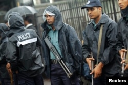 FILE - Police officers stand guard in front of the gate of International Crimes Tribunal (ICT) before a verdict against Bangladesh Jamaat-e-Islami chief Motiur Rahman Nizami in Dhaka, June 24, 2014.