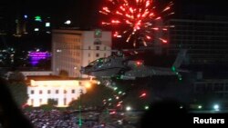 FILE - An Apache helicopter flies over Tahrir Square during a protest to support the army, in Cairo, Egypt, July 2013.