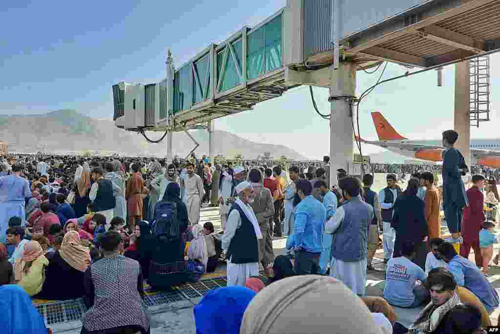 Afghans crowd at the tarmac of the Kabul airport to flee the country as the Taliban were in control of Afghanistan after President Ashraf Ghani fled the country and conceded the insurgents had won the 20-year war.