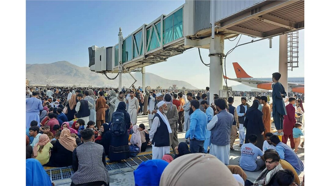 Afghans crowd at the tarmac of the Kabul airport on Aug. 16, 2021, to flee the country as the Taliban were in control of Afghanistan after President Ashraf Ghani fled the country and conceded the insurgents had won the 20-year war.