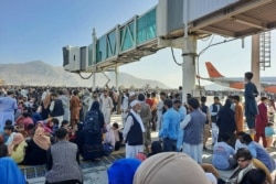 Afghans crowd at the tarmac of the Kabul airport on Aug. 16, 2021, to flee the country as the Taliban were in control of Afghanistan after President Ashraf Ghani fled the country and conceded the insurgents had won the 20-year war.