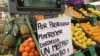 Un cartel advierte sobre mantener distancia social en un puesto de venta de frutas y verduras en Montevideo, Uruguay, el 27 de julio de 2020.