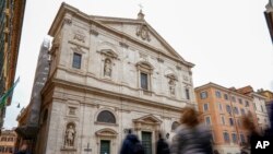 La gente camina junto a la iglesia de San Luis de Francia en Roma, el domingo 1 de marzo de 2020. La iglesia de la comunidad francesa en Roma, San Luis de los franceses, cerró sus puertas al público el domingo, según los informes, después de que un sacerdote fue infectado con el 