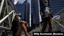 Seorang pria duduk di pinggir jembatan di Jakarta menjelang penerapan PPKM di Jawa dan Bali untuk meredam penyebaran virus corona, 2 Juli 2021. (Foto: Willy Kurniawan/Reuters) 