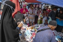 Orang-orang berbelanja di tengah pandemi virus Covid-19, di sebuah pasar di Jakarta, 28 November 2020. (Foto: AFP/Bay Ismoyo)