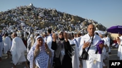 Libyan pilgrim Abdel Latif Abdel Wahab (R) prays along with family members in Saudi Arabia's Mount Arafat, also known as Jabal al-Rahma or Mount of Mercy, during the climax of the Hajj pilgrimage on June 27, 2023.