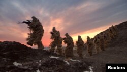 FILE - Soldiers of the People's Liberation Army (PLA) Marine Corps are seen in training at a military training base in Bayingol, Xinjiang Uighur Autonomous Region.