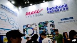 Visitors gather at a social network company booth during the 2016 Global Mobile Internet Conference in Beijing, April 28, 2016. China's legislature approved a cybersecurity law, Nov. 7, 2016, that human rights activists warn will tighten political controls and foreign companies say might isolate Chinese industries.