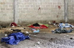 FILE - Blood is seen on the wall of a building in the Tlatlaya community after 22 people, alleged members of the drug cartel, were killed in a confrontation with soldiers of the Mexican Army, in Tlatlaya, Mexico, June 30, 2014.