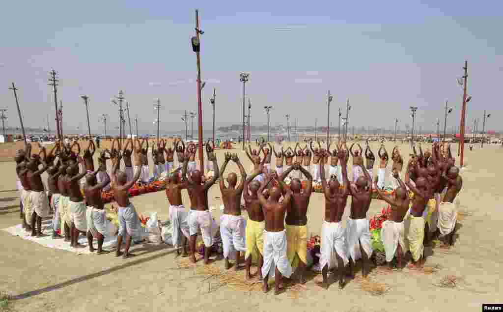 Penganut Hindu melakukan doa bersama di Sangam, pertemuan antara sungai Gangga dan Yamuna, menjelang festival Maha Shivratri di Allahabad, India utara.