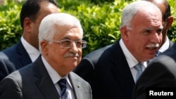 Palestinian President Mahmoud Abbas and his foreign minister Riyad al-Maliki (R) arrive for an Arab League Foreign Ministers emergency meeting at the league's headquarters in Cairo, Sept. 7, 2014.