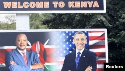 A woman sweeps next to a billboard displaying pictures of Kenya's President Uhuru Kenyatta (L) and visiting U.S. President Barack Obama, who is expected to arrive for a three-day state visit, in Kenya's capital Nairobi, July 24, 2015.