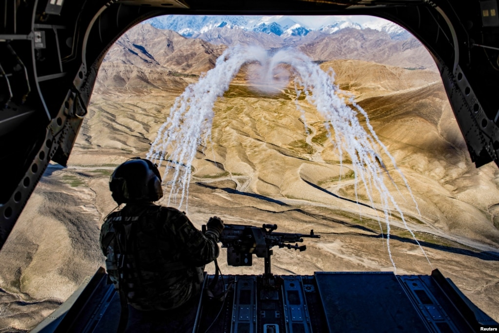 아프가니스탄에서 비행 훈련 중 CH-47F 췬욱 헬리콥터에 탑승한 미 육군 기장이 성공적인 발포를 지켜보고 있다.&nbsp;