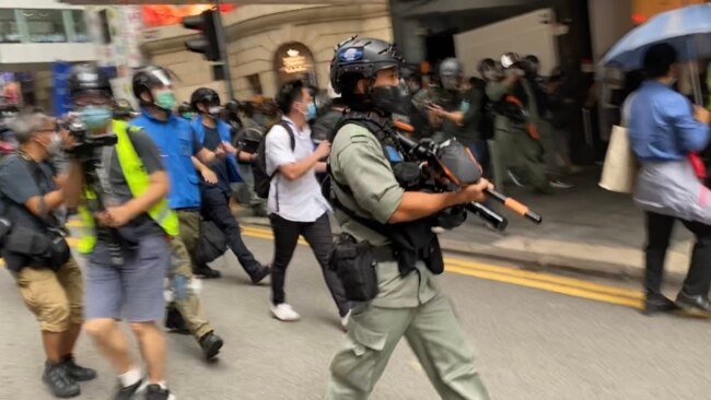 大批香港防暴警察2020年5月27日中午在中环毕打街一带多次施放胡椒球弹,驱散反对中国国歌法立法的示威群众。 (美国之音汤惠芸拍摄)