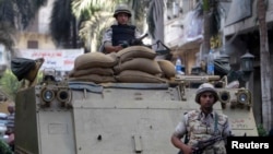 A soldier stands next to an armored personnel carrier (APC) near the Egypt stock exchange near Tahrir Square in Cairo, Sept. 17, 2013.