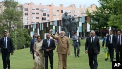 Gelombang Perdana Menteri India Narendra Modi saat berkunjung ke Kuil Radha Krishna di Lisbon, Portugal, 24 Juni 2017.