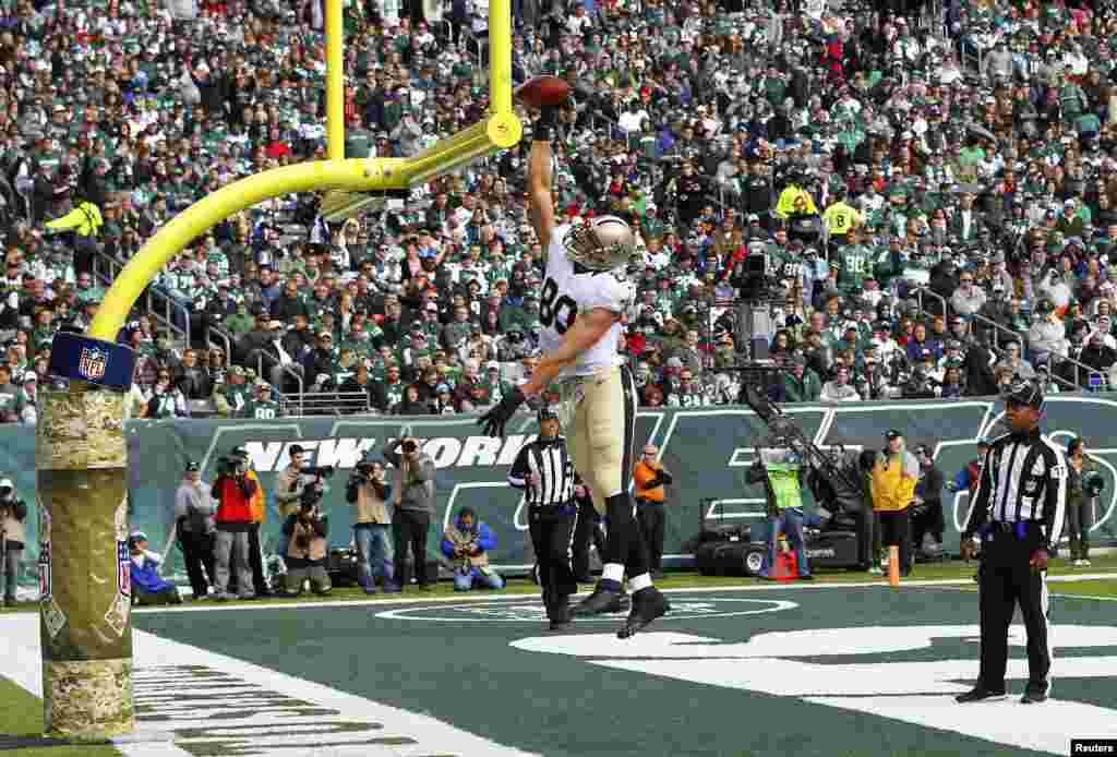 New Orleans Saints Jimmy Graham celebrates catching a touchdown pass against the New York Jets by dunking the ball over the goal post in the second quarter during their NFL football game in East Rutherford, New Jersey, USA, Nov. 3, 2013.