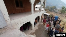 Locals gather near a house that was damaged, according to them, by cross-border shelling, in Neelum Valley, in Pakistan-administrated Kashmir, Nov. 13, 2020.