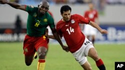 L'Egyptien Sayed Moawad, à droite, se défend contre Geremi du Cameroun, à gauche, lors des quarts de finale de CAN 2010 au Stade national d'Ombaka, à Benguela, Angola, 25 janvier 2010. 