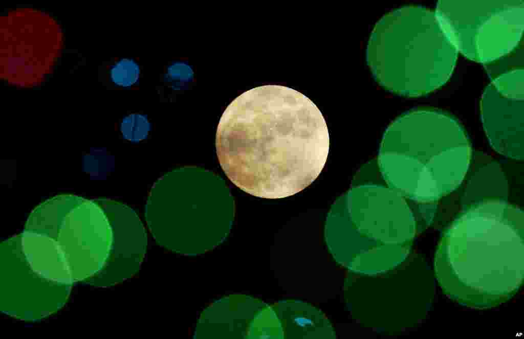 The nearly full moon is seen among Christmas lights at a holiday display near Lenexa, Kan., Dec. 24, 2015. When the moon turns full, at 5:11 a.m. CST, it will be the first full moon to fall on Christmas day since 1977.