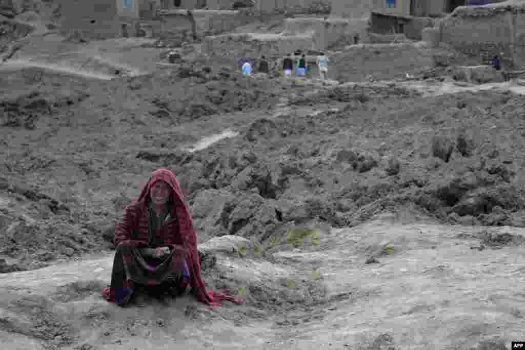 An Afghan villager cries as she sits on top of a mud field in Argo district of Badakhshan province after a massive landslid buried a village. Rescuers searched in vain for survivors after a landslide buried Aab Bareek village, killing 350 people and leaving thousands of others feared dead amid warnings that more earth could sweep down the hillside.