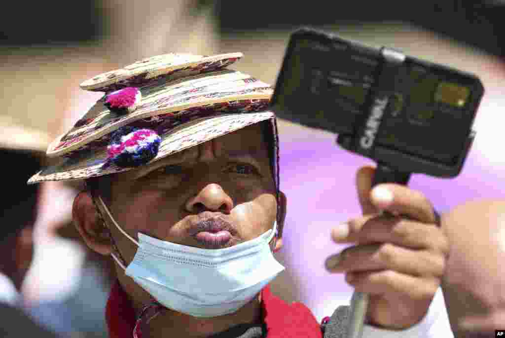 A Misak Indigenous man stikes a pose while taking a selfie during an anti-government protest against proposed tax increases on public services, fuel, wages and pensions, in Bogota, Colombia, June 2, 2021.