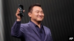 TM Roh, President and Head of Mobile Communications Business, holds a Samsung Galaxy S20 Ultra 5G phone while speaking at the Unpacked 2020 event in San Francisco, Tuesday, Feb. 11, 2020. (AP Photo/Jeff Chiu)