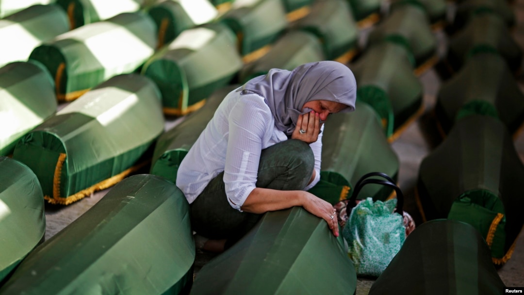 A Bosnian woman cries at a coffin of her relative, one of 173 coffins of newly identified victims from the 1995 Srebrenica massacre, in the Potocari Memorial Center, near Srebrenica, July 9, 2014. 