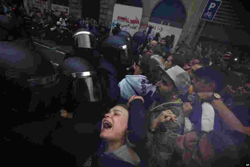 A girl grimaces as Spanish National Police pushes away pro-referendum supporters outside the Ramon Llull school assigned to be a polling station by the Catalan government in Barcelona, Oct.1, 2017.