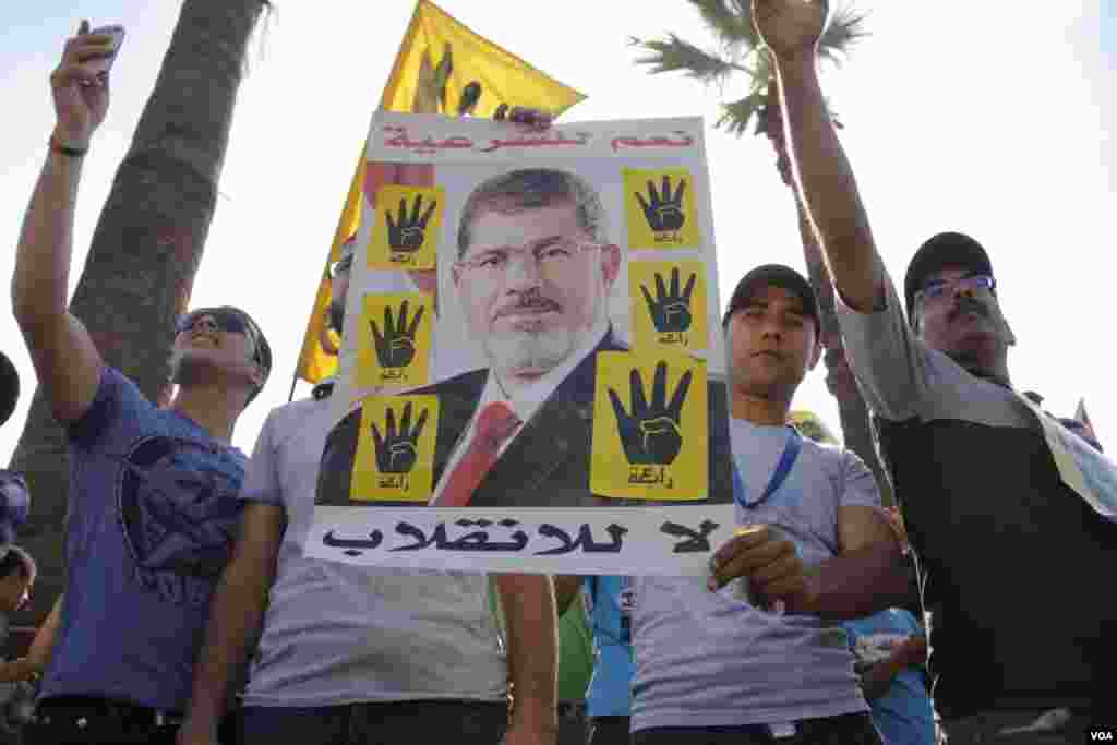 Protesters hold a poster of ousted Egyptian President Mohamed Morsi during a march in Maadi, southern Cairo, Sept. 20, 2013. (Hamada Elrasam for VOA)