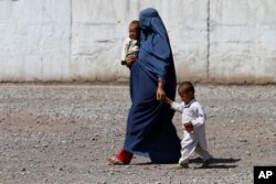 An Afghan refugee woman arrives with her children to be repatriated to Afghanistan, at the United Nations High Commissioner for Refugees office on the outskirts of Peshawar, Pakistan, April 3, 2017.