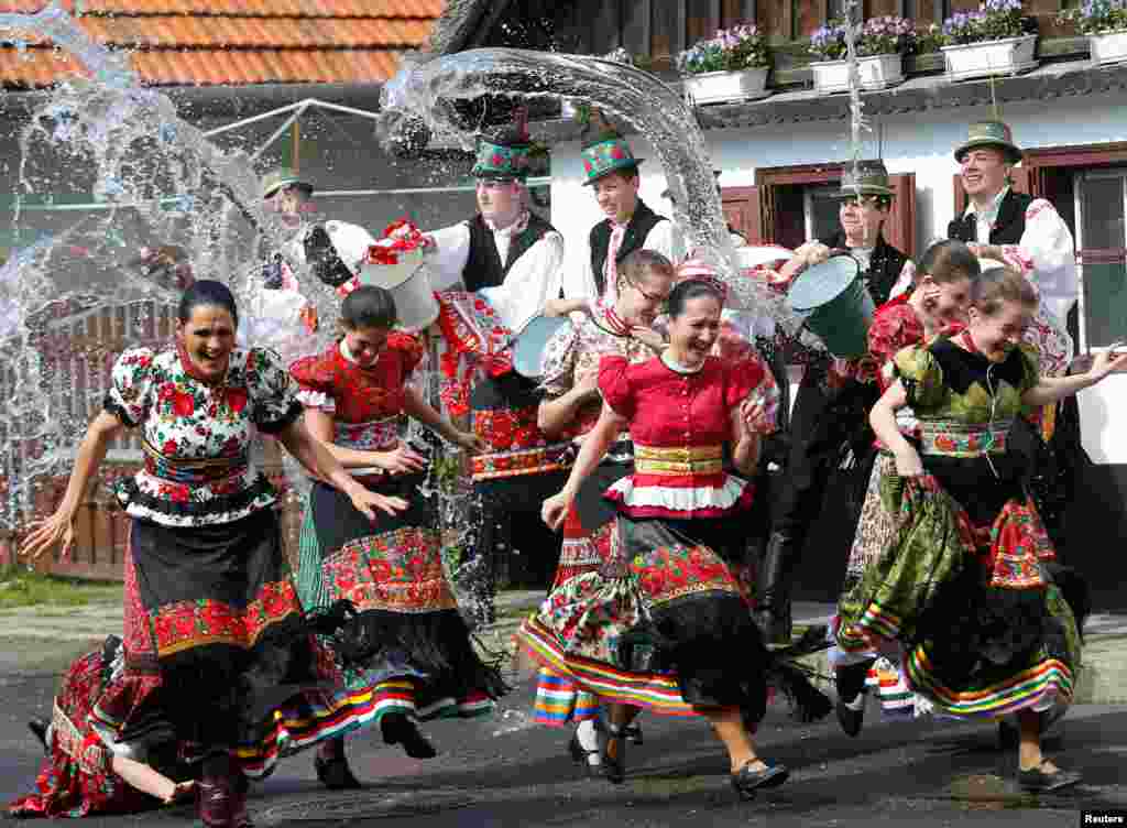 Girls dressed in traditional costumes run as men throw water on them as part of Easter celebrations in Mezokovesd, Hungary.