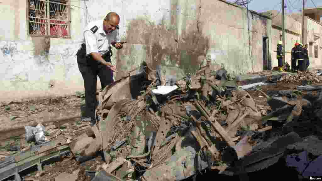 A member of the Iraqi security forces inspects the site of a car bomb attack in Kirkuk, 250 km (155 miles) north of Baghdad, April 15, 2013.